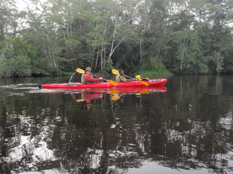 Paddling our Excursion down the Lukenie. JJ is taking a breack in the pirogue.jpg